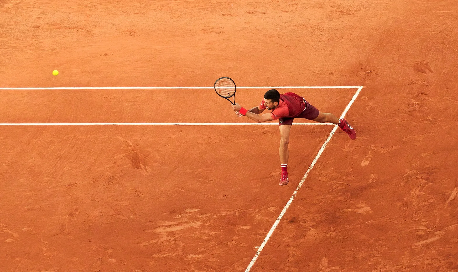 Novak Djokovic hitting a backhand at the 2024 French Open