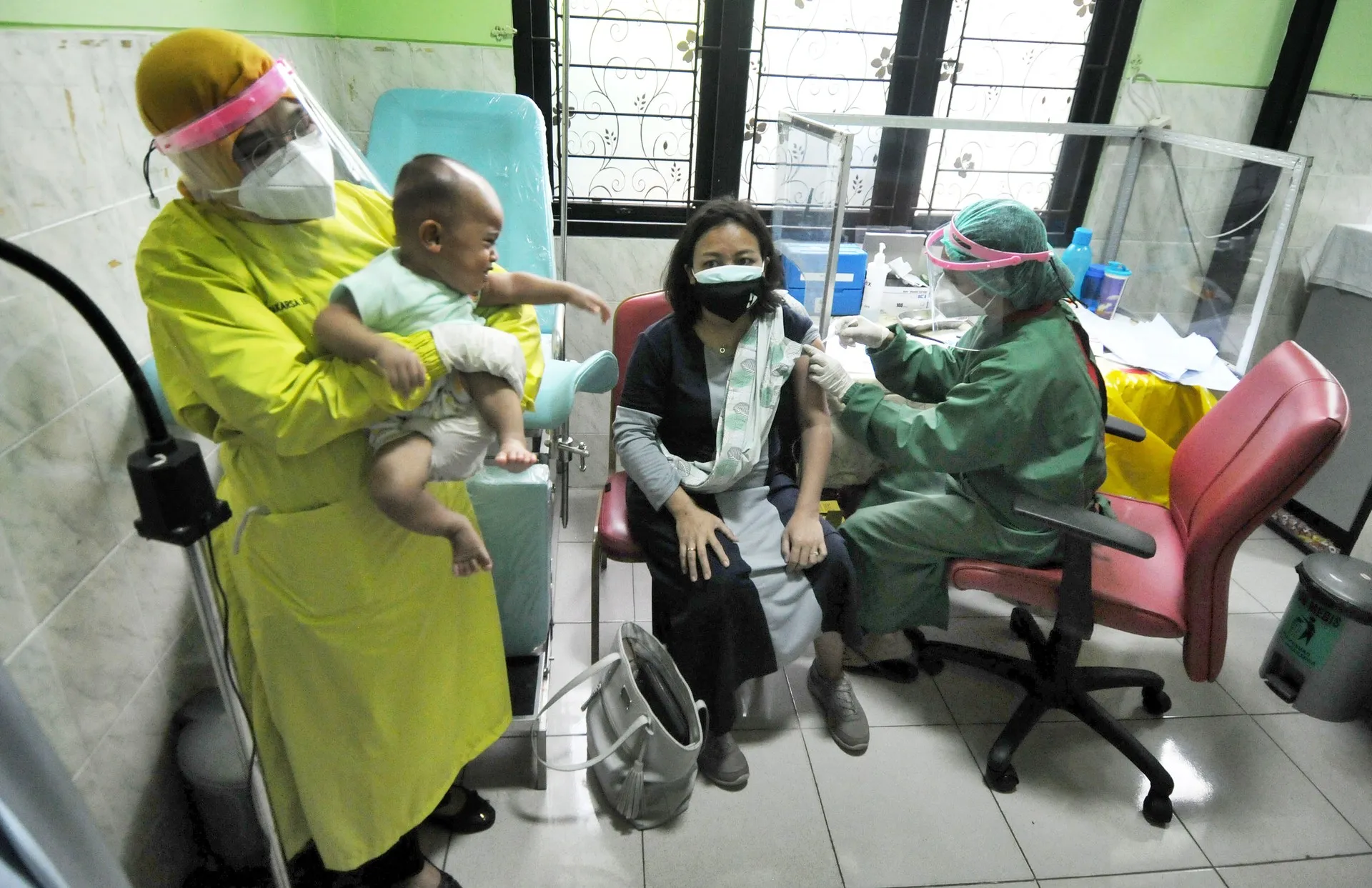 Paramedics administering a vaccine to pregnant women at a health centre